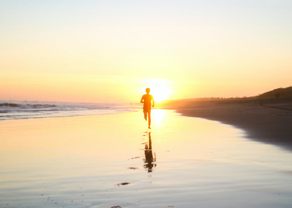 Person running into the sunset on a beach